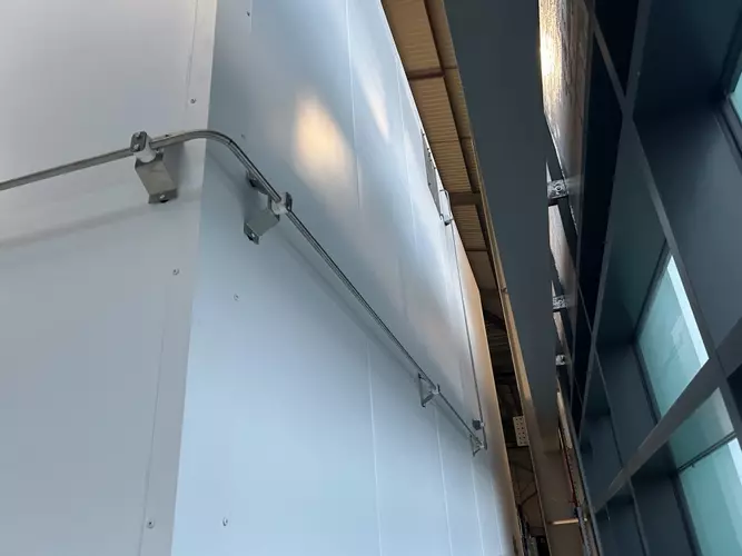 High-pressure stainless pipework routed along the rear wall to feed the wash boom at a logistics facility in Ellistown.